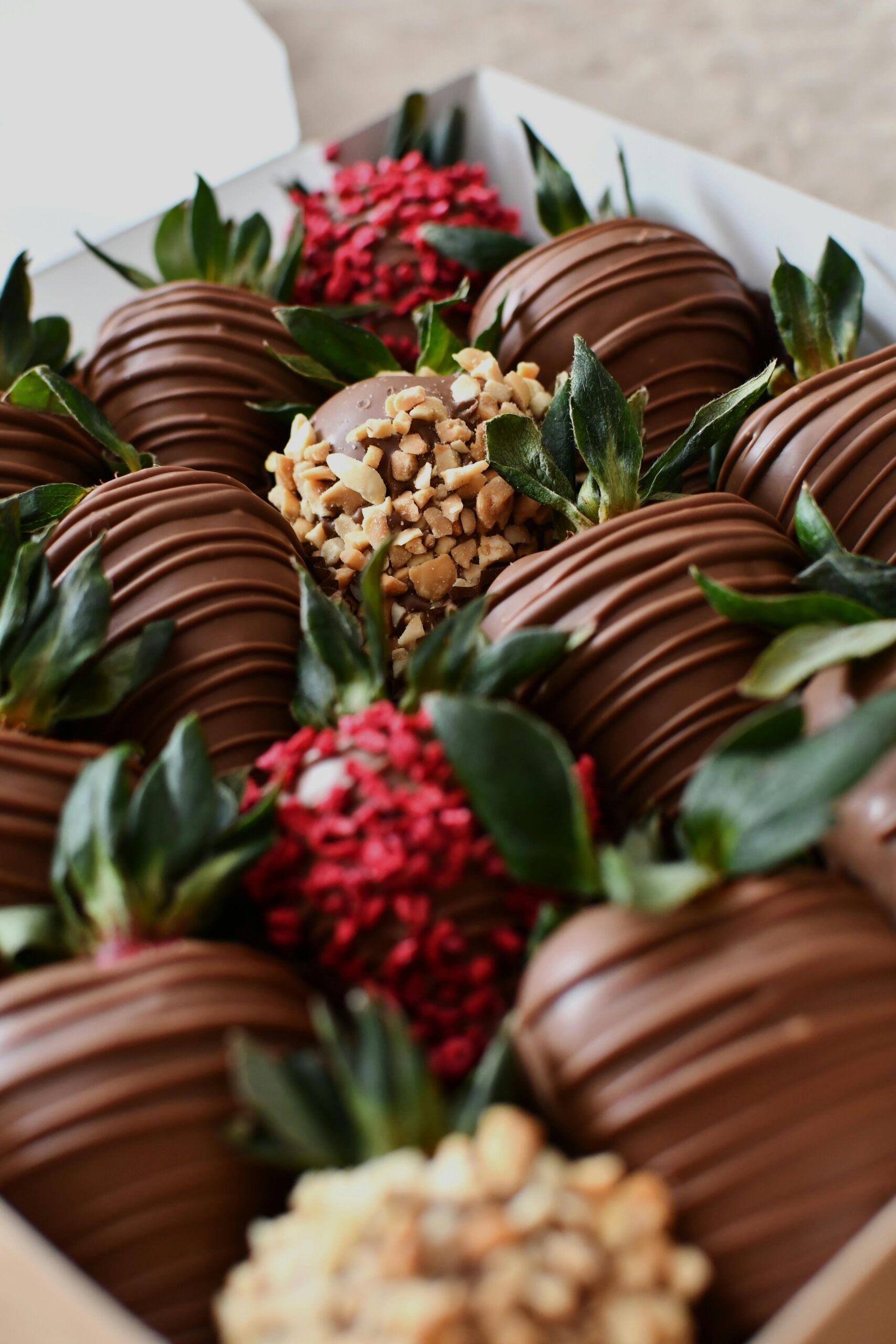 Close-up of assorted chocolate covered strawberries beautifully arranged in a box.