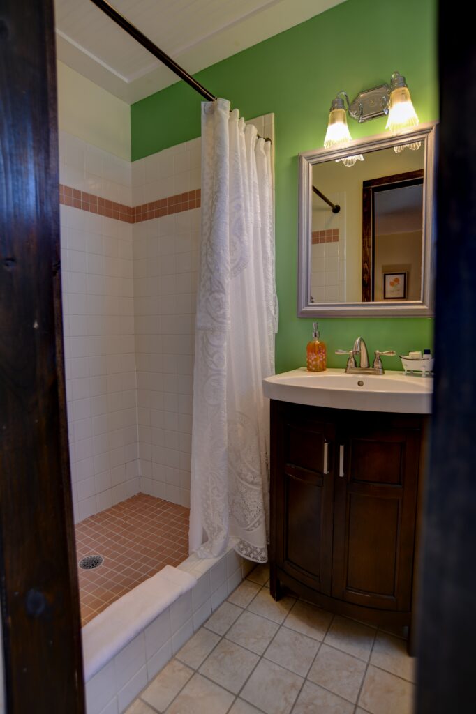 A bathroom with a shower, sink, and mirror