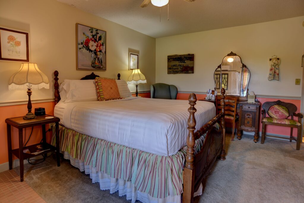 A wide view of a hotel room with a large bed, nightstands, and a sitting area.