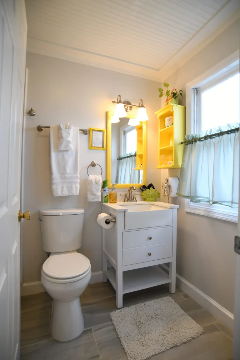 A clean and well-lit bathroom with a toilet, sink, and window.